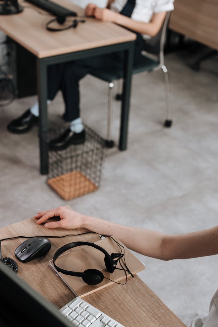 Close-up of a desk setup with headset, mouse, and keyboard indicative of a call center environment.